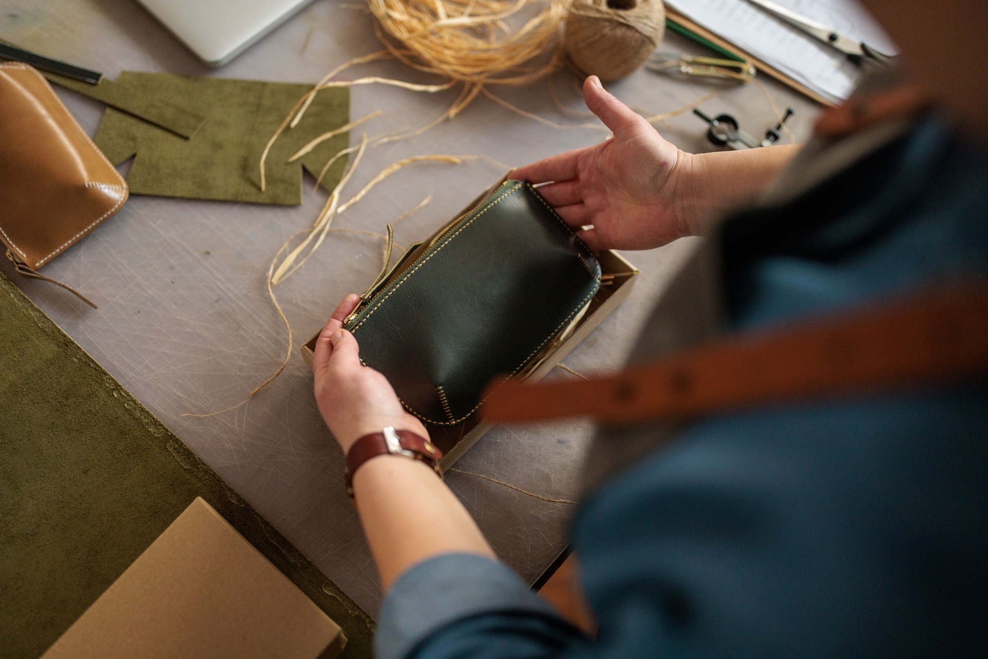 Woman Packaging Handmade Leather Wallet in Box for Shipping