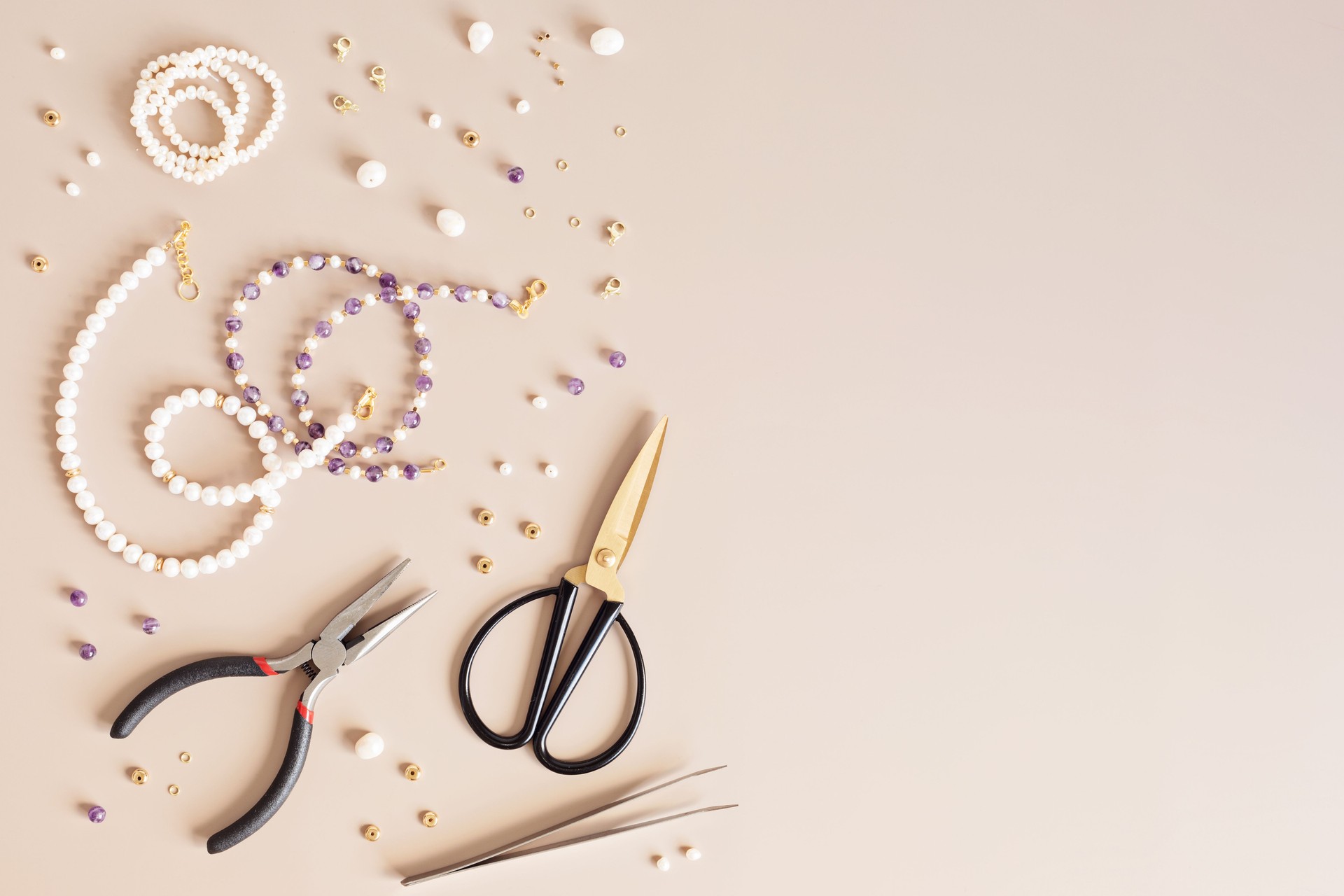 Jewelry making flatlay with semi-precious stone beads and tools. Handmade jewelry, small business, hobby concept